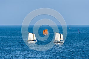 Sailboats sailing on deep blue sea