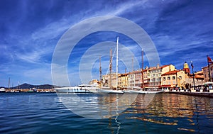 Sailboats and yachts moored to the quay port of Saint-Tropez