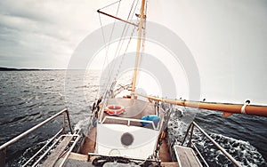 Sailing against the sun, color toned picture of an old schooner