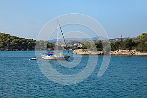 A sailing boat anchoring in a bay near Porto Heli, Peloponnese, Greece.