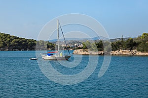 A sailing boat anchoring in a bay near Porto Heli, Peloponnese, Greece. photo