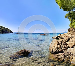 Sailing boat on crystal clear water beach in Greece