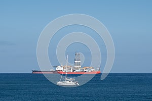 Sailing boat, drilling ship and tanker on ocean horizon -