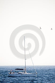 A sailing boat in a mediterranean blue sea.