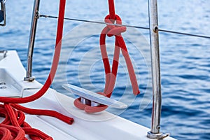 Sailing boat mooring rope tied on cleat, blur sea water background