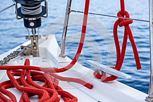 Sailing boat mooring rope tied on cleat, blur sea water background