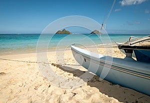 Sailing boat parked on tropical sandy beach with azure waters