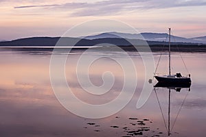 Sailing boat reflecting in calm waters