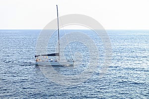 Sailing boat with resting tourists on the deck in the mediterranean sea