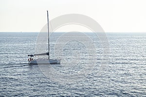 Sailing boat with resting tourists on the deck in the mediterranean sea