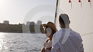 Sailing boat - Romantic young couple enjoying time together on small cruise ship sailing on open sea. Woman and man in