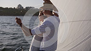 Sailing boat - Romantic young couple enjoying time together on small cruise ship sailing on open sea. Woman and man in