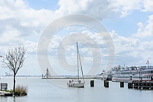 Sailing boat is sailing into the historic maritime harbor town o