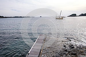 Sailing boat at sea with horizon line in the background photo