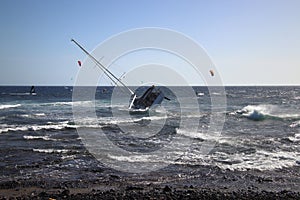 Sailing boat of tourists keel over at rocky shore (Tenerife Island, Spain)