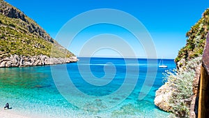 A sailing boat into the turquoise Mediterranean Sea, at San Vito Lo Capo, Sicily