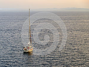 Sailing boat yacht at sunset in Roses Bay at Costa Brava, Catalonia