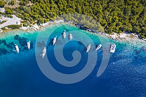 Sailing boats at anchor in blue bay of Fiskardo, Kefalonia island, Ionian, Greece. Aerial drone photo