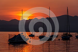 Sailing Boats on lake Garda with sunset, Italy