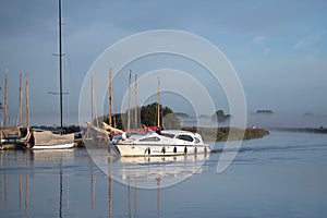 Sailing boats and a luxury cruiser  on the Norfolk Broads