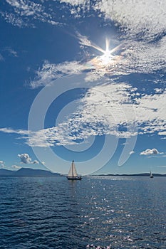 Sailing boats on natural water clouds blue sky sun