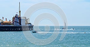 Sailing boats and water jet skis at Brighton pier