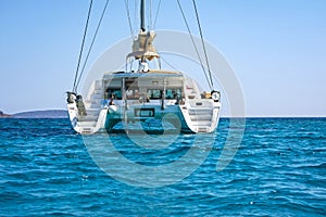 Sailing catamaran in blue waters of the Aegean sea.