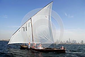 Sailing Dhow Against The Distant Cityscape Of Duba