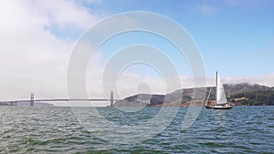 Sailing down the San Francisco bay on a small yacht in California near a Golden Gate bridge