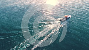 Sailing fishing boat in the sea water early in the morning and beautiful sunrise