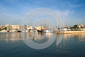 Sailing, motor boats and a small fishing boat crossing calm waters in the harbor of marina Zeas .Pireas.Greece.