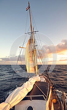 Sailing old schooner at sunset, travel and adventure concept