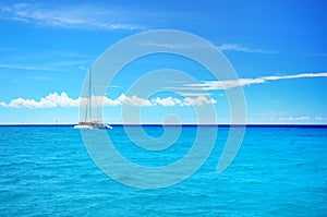 Sailing party catamaran in the blue carribean sea and cloudscape