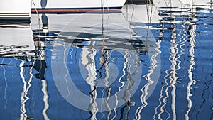 Sailing. Reflection of yacht masts in the water of the Harbor.