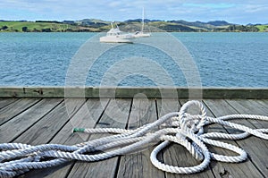 Sailing rope on a wharf pier with boats in the bac