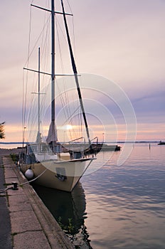 Sailing ship in the harbor of lake Vaettern at sunset. Lighthouse in the background