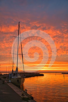 Sailing ship in the harbor of lake Vaettern at sunset. Lighthouse in the background