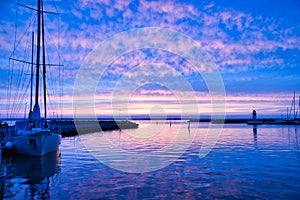 Sailing ship in the harbor of lake Vaettern at sunset. Lighthouse in the background