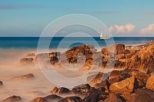 Sailing ship on horizon of blue ocean