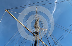 Sailing ship mast against the blue sky on some sailing boats with rigging details