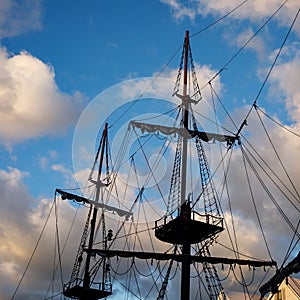 Sailing ship mast with rigging and cables against the sky.