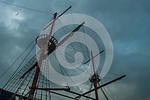 Sailing ship masts against stormy sky