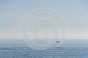 sailing ship with sails lowered, the horizon in the background and the sea calm