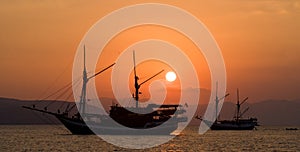 Sailing ship on the sea at sunrise sunset. Indonesia. Islands.