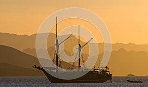 Sailing ship on the sea at sunrise sunset. Indonesia. Islands.