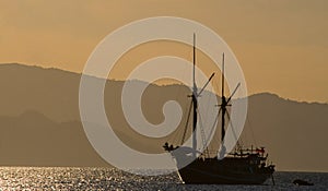 Sailing ship on the sea at sunrise sunset. Indonesia. Islands.