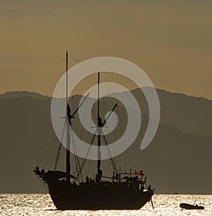 Sailing ship on the sea at sunrise sunset. Indonesia. Islands.