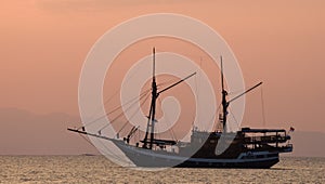 Sailing ship on the sea at sunrise sunset. Indonesia. Islands.