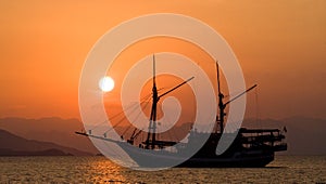 Sailing ship on the sea at sunrise sunset. Indonesia. Islands.