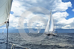 Sailing ship yachts with white sails in sea in stormy weather. Nature.